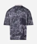 Remera de corte boxy confeccionada en tejido jacquard de poliéster con textura. Presenta cuello polo en color blanco con detalles en negro, mangas cortas y estampado frontal con lettering Bruxo y logo de Ronaldinho.