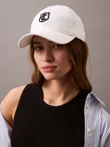 Gorra de algodón color blanco con logo bordado en negro en el frente. Diseño clásico con cierre ajustable en la parte posterior.