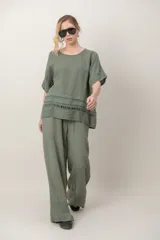 Blusa de lino color blanco, de corte amplio, con escote redondo, mangas cortas y detalle de guarda calada horizontal en la parte inferior.