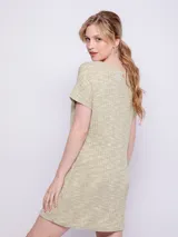 Vestido corto color verde claro, de tela con textura acanalada y cuello redondo. Es de manga corta y corte recto.