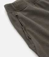 Pantalón deportivo de corte ajustado, confeccionado en tejido de poliéster texturizado color negro. Presenta cintura elástica con cordón de ajuste, bolsillos laterales con cierre y puños elásticos en los tobillos.