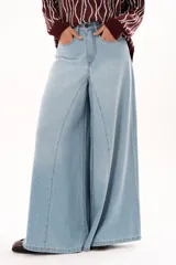 Jean de tiro alto con diseño de pierna extra ancha y caída fluida. Cuenta con bolsillos delanteros y traseros, cierre frontal con cremallera y botón metálico.