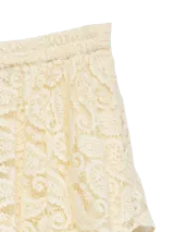 Falda midi asimétrica de encaje color crudo, con diseño de capas superpuestas y cintura elastizada.