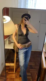 Top negro de estilo halter con espalda descubierta y tiras ajustables para atar. Confeccionado en tejido elástico, presenta un diseño versátil y moderno.