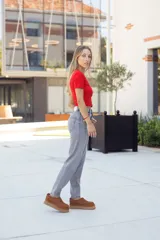 Calzado tipo sueco o zueco de cuero color óxido (marrón claro/camel), con diseño cerrado tipo mocasín y plataforma gruesa de goma color beige. Presenta un tirador de tela rojo en el talón.