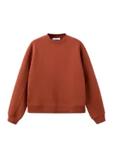 Jersey de punto liso en color marrón terracota, con cuello redondo y diseño de manga larga con puños y bajo de canalé.