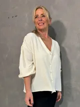 Sobrecamisa de viscosa con detalle de lurex en color marfil, con escote en V, cierre frontal abotonado y mangas abullonadas.