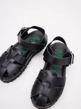 Sandalias tipo romanas de cuero vacuno color beige, con diseño de tiras entrelazadas, hebilla metálica lateral y plataforma de goma dentada.