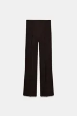 Pantalón de tiro alto con raya planchada en el delantero, corte flare con aberturas en el bajo y cierre lateral con cremallera oculta.