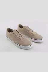 Championes urbanos de lona color beige, con cordones al tono y suela de goma blanca con detalle de línea negra.