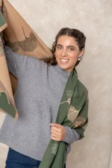 Pashmina reversible de textura suave y caída fluida, con diseño estampado de hojas de ginkgo biloba. Presenta un lado con fondo oscuro y otro con fondo claro, finalizando en ambos extremos con flecos cortos deshilachados.