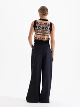 Pantalon de vestir azul marino con corte wide leg, tiro alto y pinzas frontales que aportan volumen. Cuenta con cierre frontal, doble gancho de ajuste y presillas con detalles de remaches metálicos.