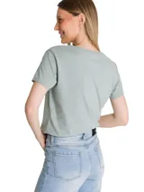 Remera de cuello en V color verde menta con estampa frontal del logo de la marca en tono azul metalizado. Presenta mangas cortas y un corte clásico.