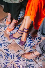 Zapatos de tacón color lila con glitter, punta redondeada y doble tira con hebilla en el tobillo.