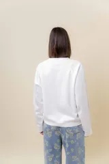 Buzo de manga larga color verde claro, con cuello redondo y calce relajado.