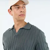 Remera polo de punto calado, color verde militar, de manga corta, con cuello tipo polo y abertura frontal en V.