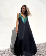 Vestido largo de corte holgado en color negro, con escote en V profundo decorado con apliques de lentejuelas en color verde esmeralda.