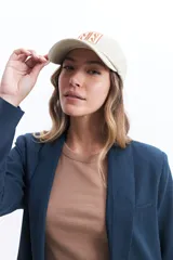 Blazer color beige estilo lino, de corte recto y largo a la cadera.