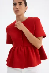 Top rojo de manga corta con escote redondo, botones forrados adelante y peplum.