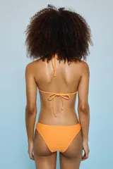 Conjunto de bikini color naranja claro, con corpiño triangular de atar al cuello y bombacha de corte clásico.
