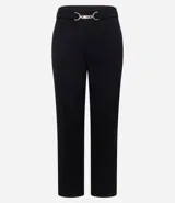 Pantalón de vestir negro confeccionado en malla punto roma, de corte largo y ligeramente afunilado. Presenta cintura alta con un adorno metálico decorativo en el frente y costuras verticales que estilizan la silueta.