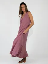 Vestido largo sin mangas, con escote en V, corte holgado y detalles de volados con flecos en el ruedo.