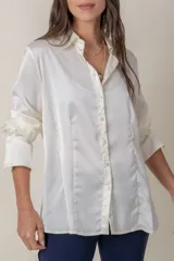 Camisa de seda con acabado satinado, de corte holgado y manga larga con puños anchos. Presenta cuello clásico y cierre frontal con botones al tono.