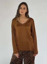 Blusa color beige con escote en V con detalle de strass y mangas largas.