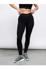 Calza deportiva Umbro para mujer de color negro, de tiro alto con diseño cruzado en la cintura y elástico con la marca impresa.