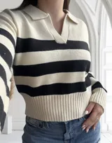 Sweater de punto a rayas horizontales blancas y negras, con cuello polo y corte clásico.