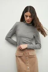 Polera gris de manga larga y cuello alto, confeccionada en tejido suave y ligero.
