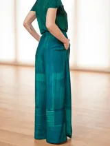 Mono de vestir verde esmeralda con estampado abstracto, escote en V, mangas cortas y pantalón palazzo con aberturas laterales.