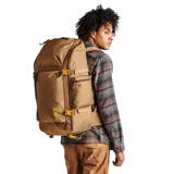 Mochila de gran capacidad con diseño técnico, color marrón con detalles en amarillo. Cuenta con múltiples compartimentos con cierre, correas de compresión laterales, panel trasero ergonómico y compartimento para laptop.