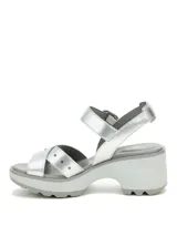 Sandalia plateada con tiras cruzadas y detalles de tachas, sujeción con hebilla al tobillo y plataforma con suela dentada.