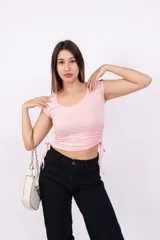 Remera de mangas cortas color rosa, con escote redondo y frunce lateral con lazos.