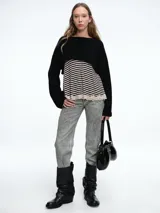 Sweater de punto negro con diseño corto (crop), cuello bote y mangas largas holgadas.