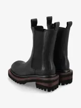 Bota de cuero premium color negro, de diseño minimalista estilo Chelsea con elásticos laterales y tiradores superiores. Posee una suela track de goma con plataforma y taco cuadrado con detalle de madera.