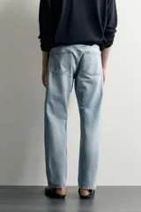 Jeans regular fit confeccionados en denim de algodón celeste con efecto lavado, de cinco bolsillos y cierre frontal con cremallera y botón.