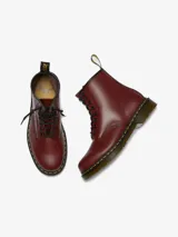 Bota Dr. Martens modelo 1460 de cuero color cereza, con 8 ojales, costuras amarillas y suela con cámara de aire.