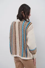 Cardigan de punto con escote en V y cierre frontal de botones. Presenta un diseño estampado con patrones geométricos en tonos beige, marrón y detalles en azul vibrante.