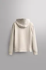Sudadera de hombre Zara Athleticz de ajuste relajado (relaxed fit), color marrón, confeccionada en tejido técnico compacto con mezcla de algodón y elasticidad. Cuenta con cuello con capucha ajustable con cordones negros, manga larga, bolsillo frontal tipo canguro con un pequeño bolsillo termofijado con cierre, y acabados con rib en puños y cintura.