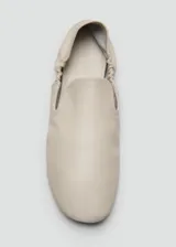 Zapato tipo flat de cuero ovino en color blanco, con diseño de punta redonda y detalle de fruncido elástico en el empeine.