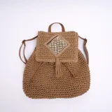 Mochila marrón de yute con solapa y cierre de cordón ajustable.