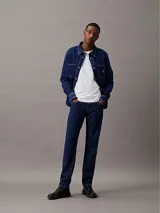 Jeans de denim azul índigo oscuro, corte slim fit, talle medio y pierna estrecha.