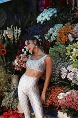 Calza deportiva tiro alto de cintura ancha, color blanco roto con estampado repetitivo en gris.