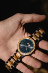 Reloj Vernoir con caja de madera de Zebrano y malla de Chacate Preto con incrustaciones de madera de Zebrano. Esfera negra con marcadores minimalistas en blanco y manecillas negras.