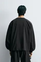 Cazadora de corte boxy fit confeccionada en tejido técnico. Presenta cuello redondo, cierre frontal con botones a presión, mangas largas con puños elásticos y bolsillos tipo plastrón con solapa en la parte frontal.
