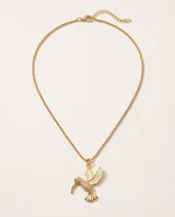 Collar de bronce dorado con cadena fina y dije colgante en forma de colibrí con detalles texturizados.