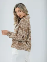 Camisa color crema con bordados florales, de corte recto y mangas largas.
