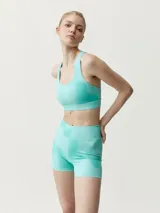 Top deportivo color turquesa, de corte ajustado, con cuello redondo y espalda nadadora.